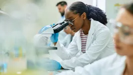 Woman scientist looking through a microscope